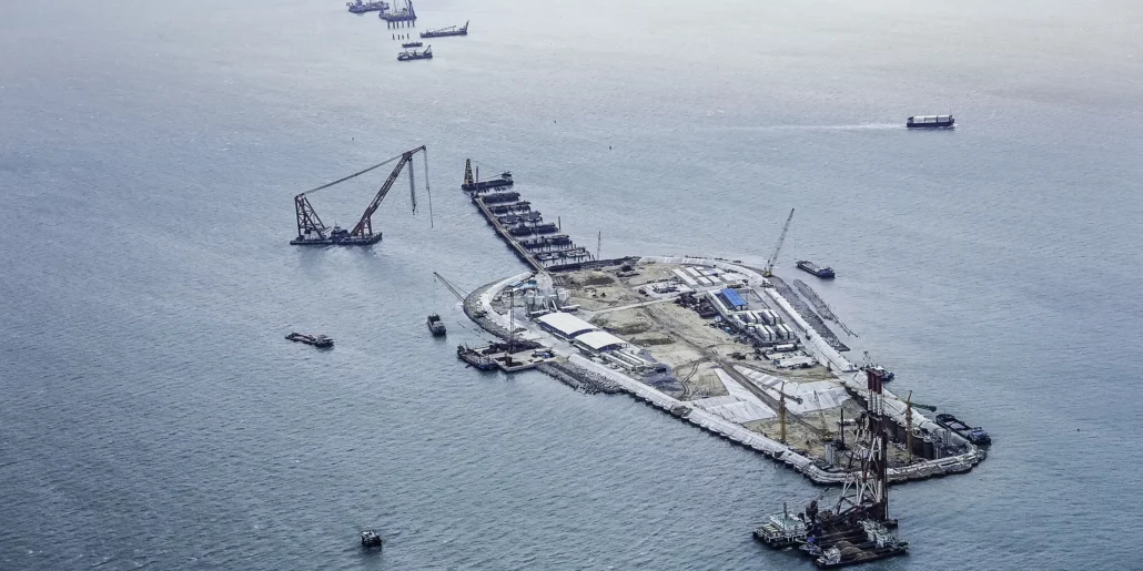 Aerial view of an offshore construction platform surrounded by crane vessels and smaller workboats.